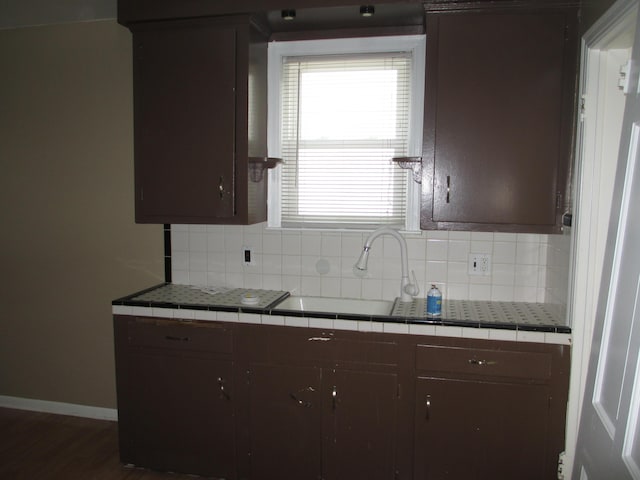 kitchen featuring tasteful backsplash, tile countertops, and dark brown cabinets