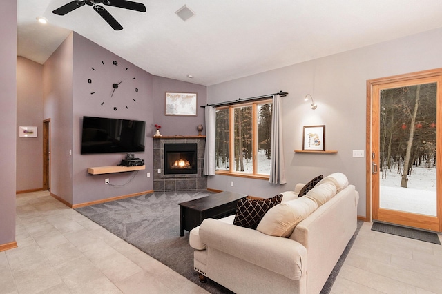 carpeted living room with lofted ceiling and a tiled fireplace