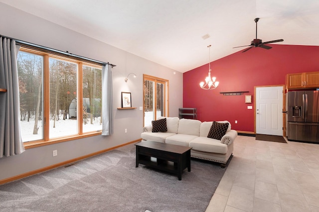 living room with ceiling fan with notable chandelier and high vaulted ceiling