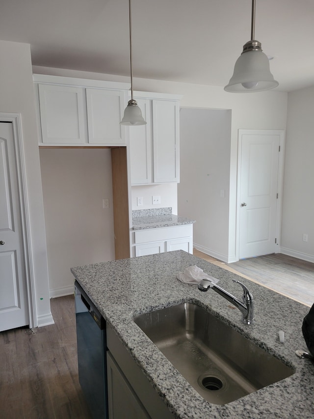 kitchen with pendant lighting, white cabinets, sink, and dishwasher