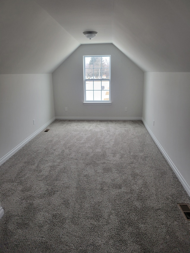 bonus room featuring vaulted ceiling and carpet flooring