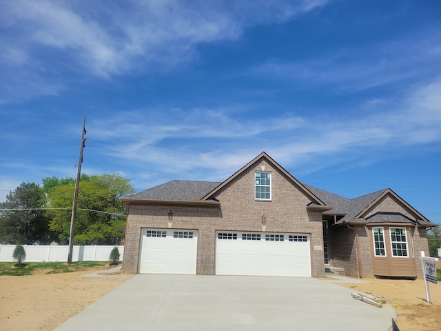20257 Sunset, Livonia, MI 48152 - view of front facade with brick siding, concrete driveway, fence, a garage, and a shingled roof