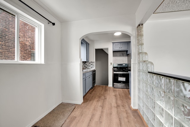 kitchen featuring gray cabinets, dishwasher, tasteful backsplash, stainless steel range with electric cooktop, and light wood-type flooring