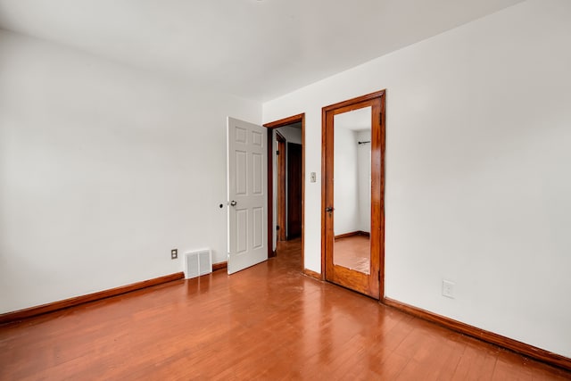 empty room with hardwood / wood-style flooring