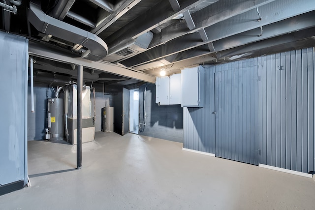 basement featuring heating unit and water heater