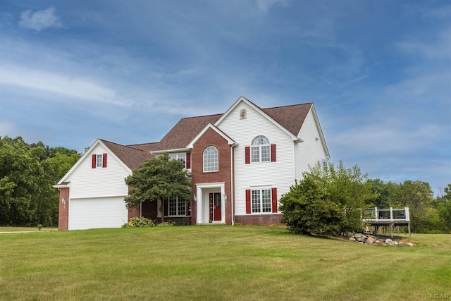 colonial home featuring a garage and a front lawn