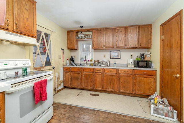 kitchen featuring pendant lighting, wood-type flooring, sink, and white range with electric stovetop