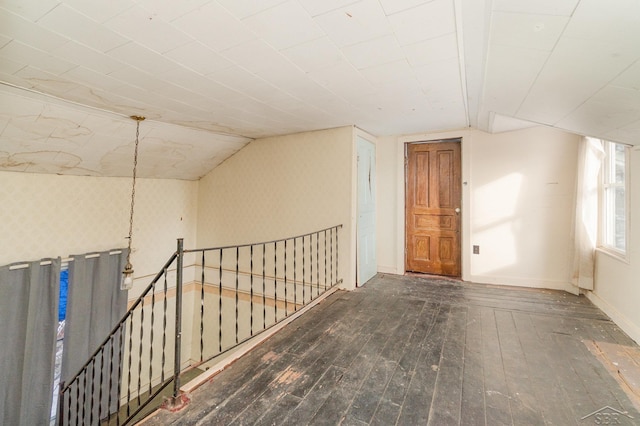 bonus room with dark hardwood / wood-style floors and vaulted ceiling