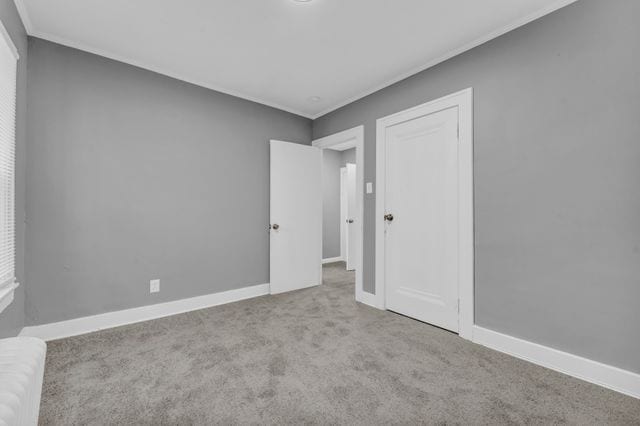 carpeted empty room with crown molding