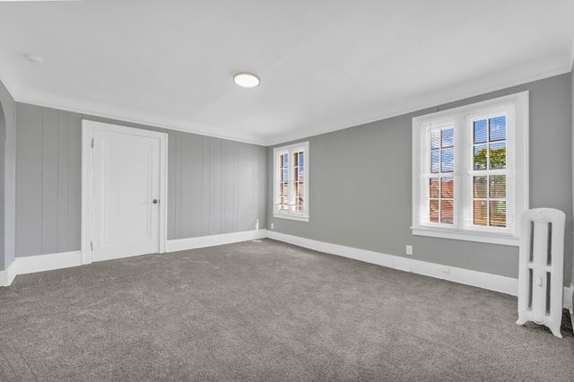 carpeted empty room featuring ornamental molding