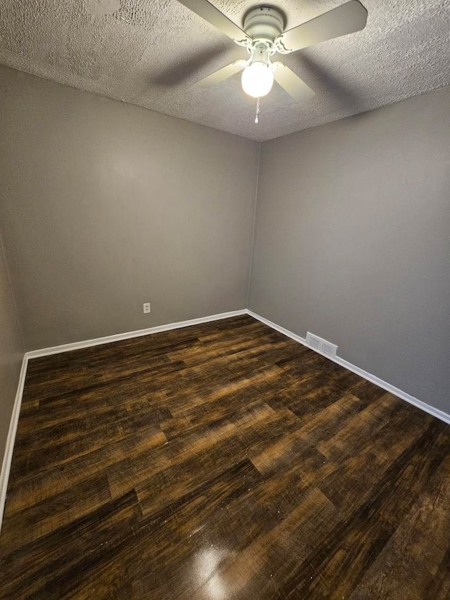 empty room featuring ceiling fan, dark hardwood / wood-style flooring, and a textured ceiling