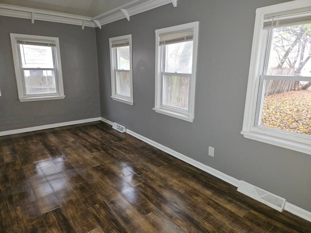 empty room featuring ornamental molding and dark wood-type flooring