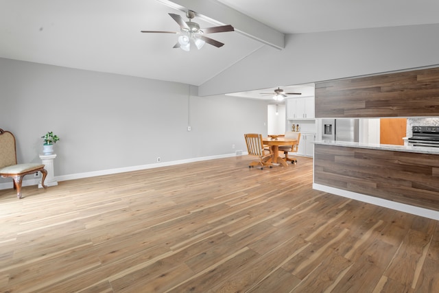 interior space featuring vaulted ceiling with beams, ceiling fan, and light hardwood / wood-style flooring