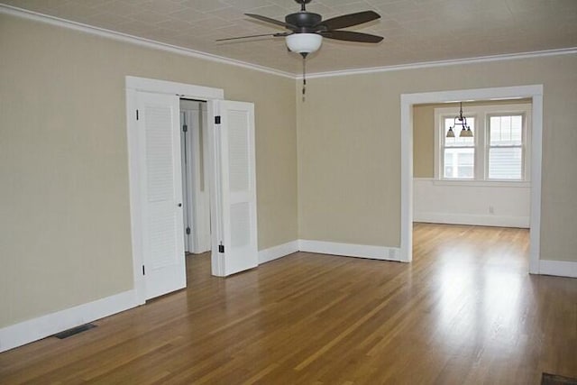 spare room with crown molding, ceiling fan, and hardwood / wood-style flooring