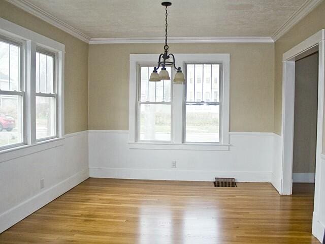 unfurnished dining area with wood-type flooring and ornamental molding