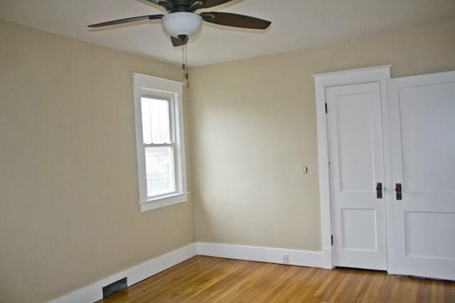 unfurnished bedroom with hardwood / wood-style flooring, ceiling fan, and a closet