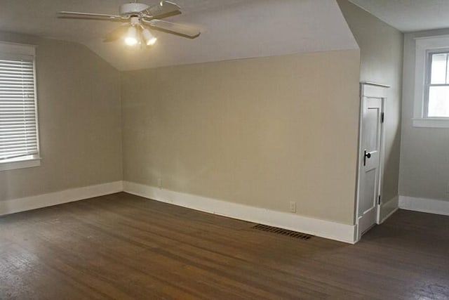 empty room featuring ceiling fan, lofted ceiling, and dark hardwood / wood-style flooring