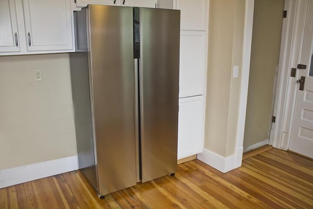 307 New York Ave, Dowagiac, MI 49047 - kitchen with freestanding refrigerator, white cabinets, and light wood-style floors