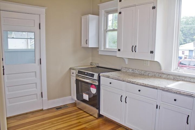 307 New York Ave, Dowagiac, MI 49047 - kitchen featuring electric stove, white cabinets, and light wood finished floors