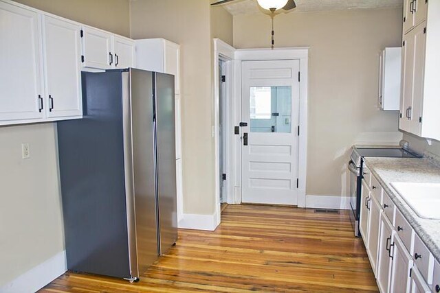 307 New York Ave, Dowagiac, MI 49047 - kitchen featuring stainless steel appliances, light wood-style floors, white cabinets, light countertops, and ceiling fan