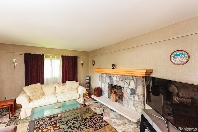 living room featuring a stone fireplace