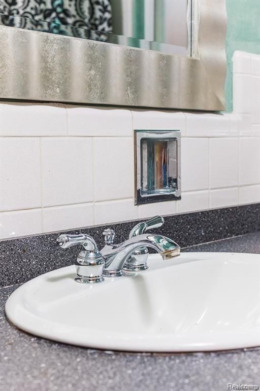 interior details featuring sink and decorative backsplash