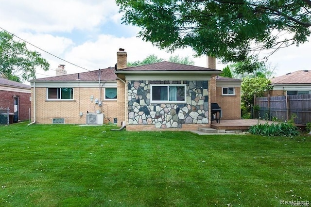 back of property featuring central AC, a deck, and a lawn