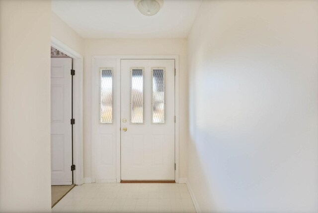 doorway featuring baseboards