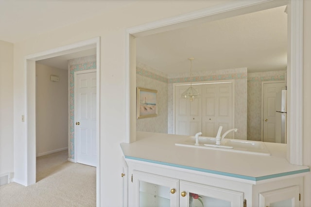 kitchen featuring baseboards, carpet floors, wallpapered walls, freestanding refrigerator, and light countertops