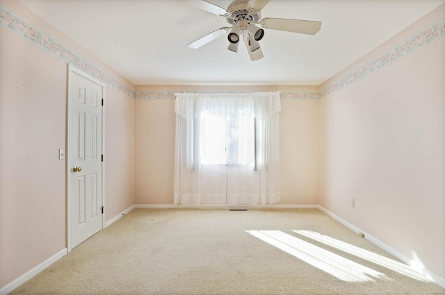 carpeted empty room with baseboards and ceiling fan