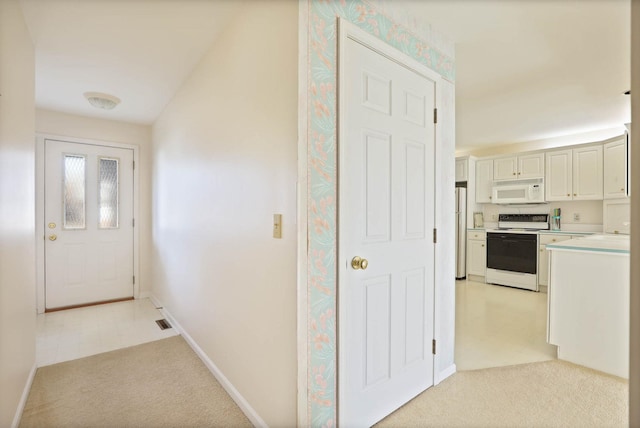 corridor with visible vents, baseboards, and light colored carpet