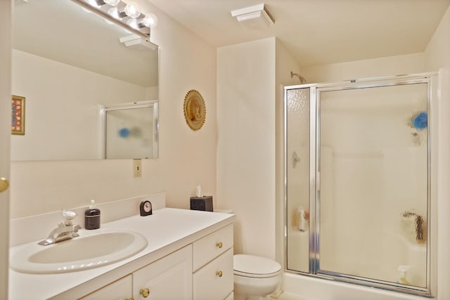 full bathroom with vanity, a shower stall, and toilet