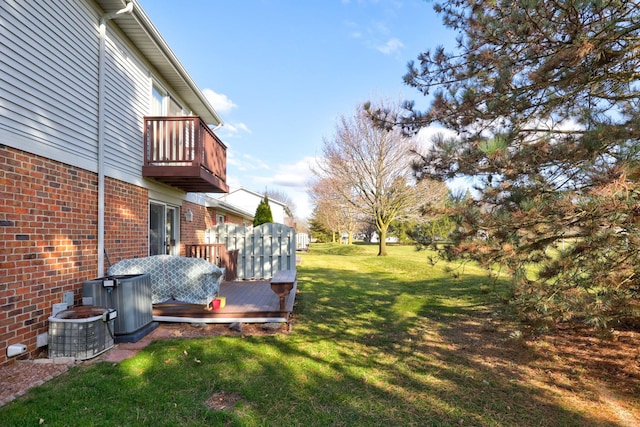 view of yard with central air condition unit, a wooden deck, and a balcony