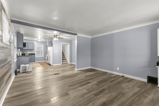 unfurnished living room with wood-type flooring and ceiling fan