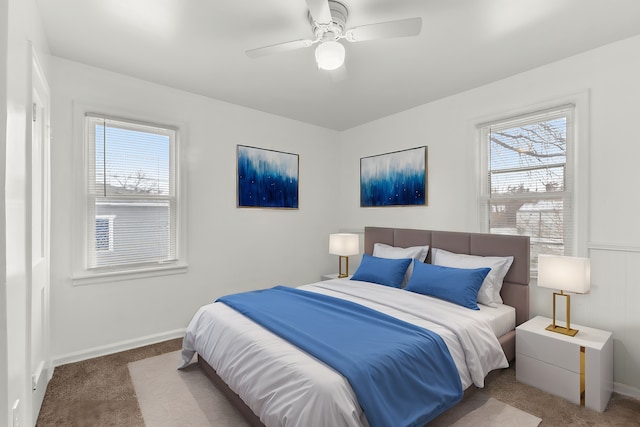 bedroom with ceiling fan, carpet floors, and multiple windows