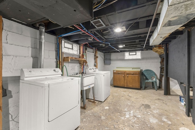 washroom with sink, cabinets, and washing machine and clothes dryer