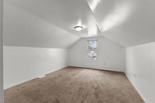 additional living space featuring lofted ceiling and carpet