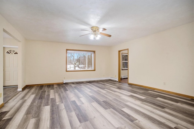 empty room featuring hardwood / wood-style flooring, a baseboard radiator, and ceiling fan