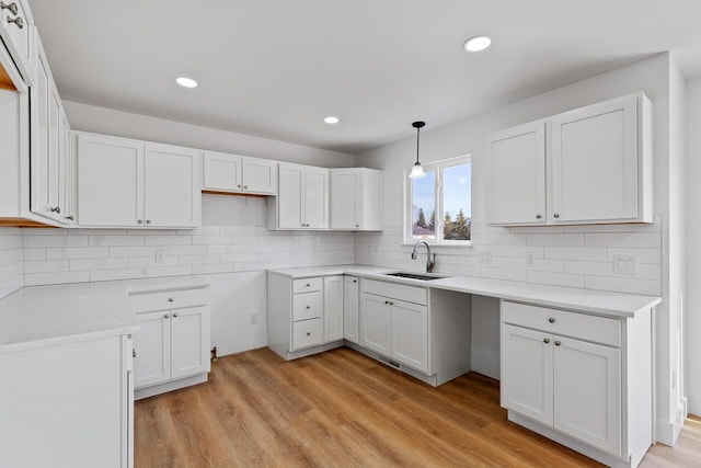 kitchen with white cabinetry, sink, and pendant lighting