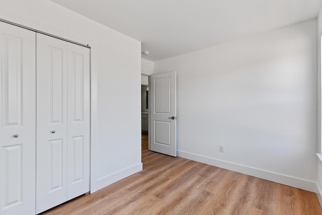 unfurnished bedroom featuring a closet and light wood-type flooring