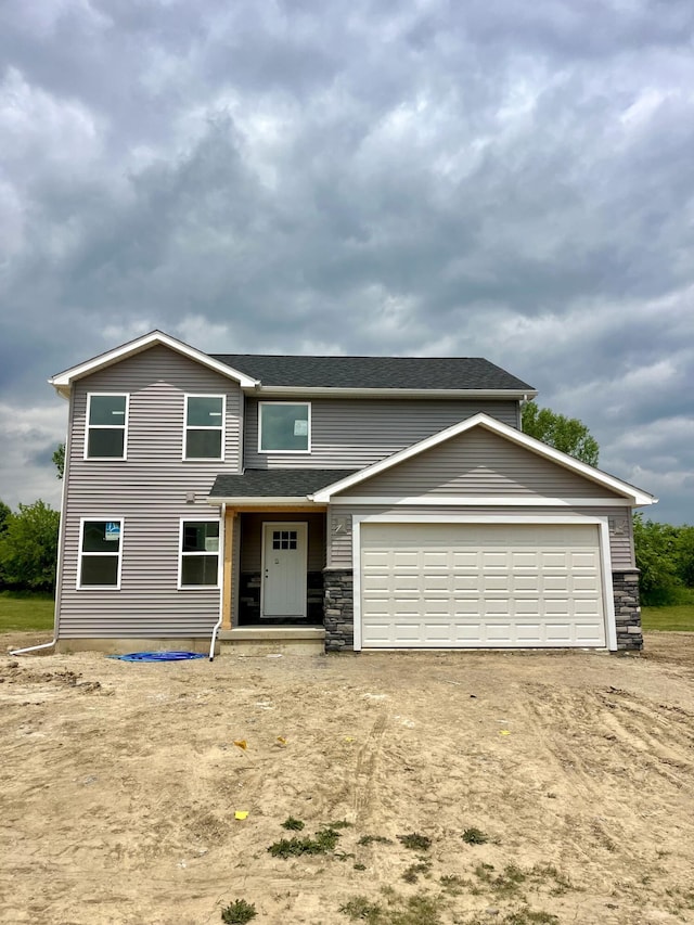 2014 Green Acres Dr, Adrian, MI 49221 - view of front of home featuring stone siding, dirt driveway, roof with shingles, and a garage