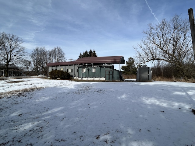 snow covered property with a storage shed