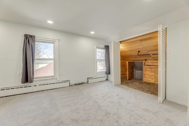 unfurnished living room featuring a baseboard radiator, lofted ceiling, wooden walls, and carpet