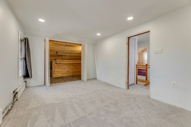 unfurnished bedroom featuring baseboard heating and light colored carpet