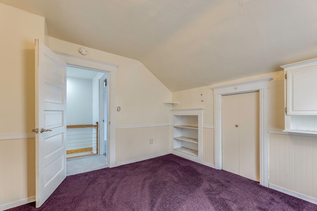 unfurnished bedroom with vaulted ceiling and carpet flooring