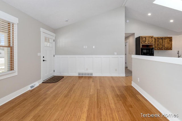 interior space with vaulted ceiling and light wood-type flooring