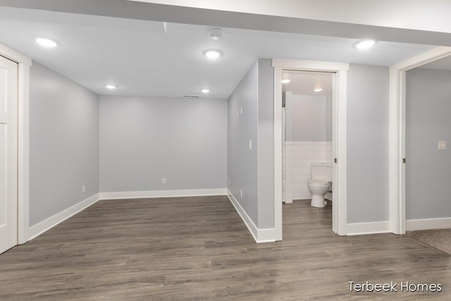 basement with dark hardwood / wood-style floors