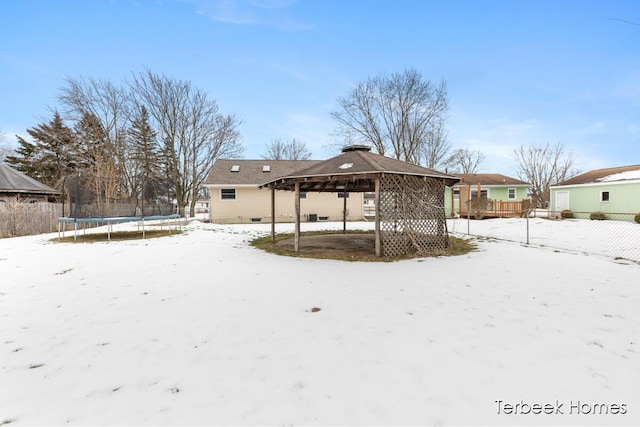 snow covered property featuring a trampoline and a gazebo