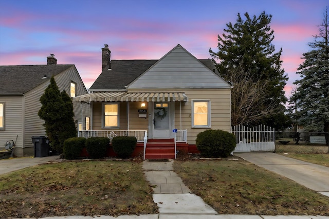 bungalow-style home with a yard and a porch