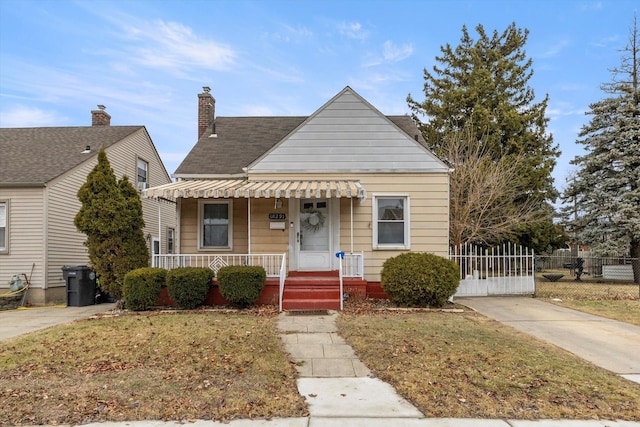 bungalow with a porch and a front lawn